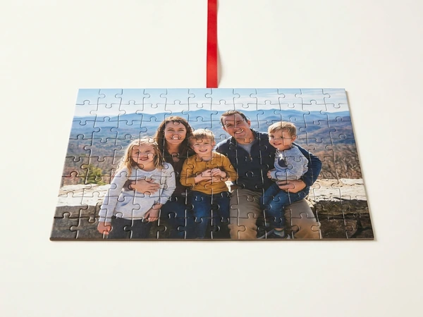 Photo puzzle hung on red ribbon of a family of five on a mountain wall