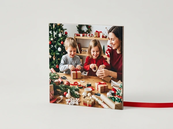 MIXPIX tile of a woman, a boy and a girl wrapping presents with red ribbon at a table