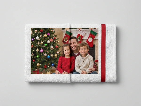 White photo towel of a man, a girl and a boy smiling under Christmas stockings by the tree