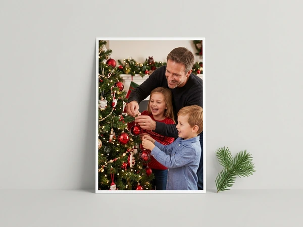 White border poster of a man, a girl and a boy hanging red ornaments on a Christmas tree