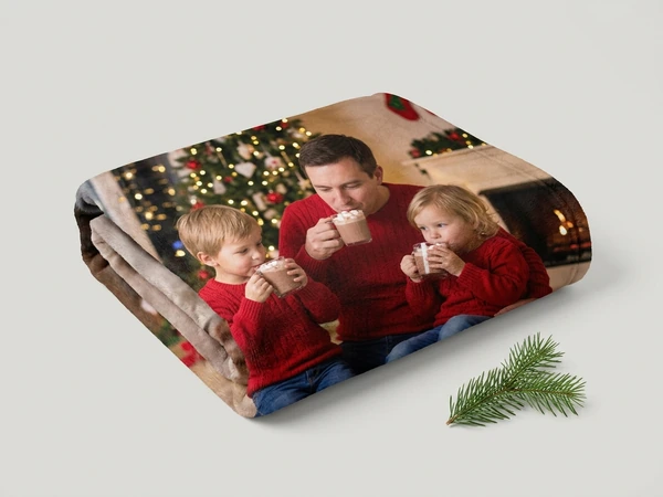 Plush blanket of a man and two children in red sweaters sipping cocoa by a Christmas tree