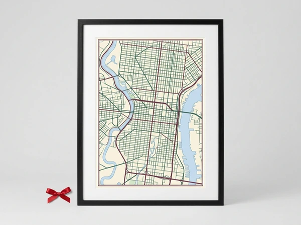 Black framed city map poster with green streets and a blue river on cream