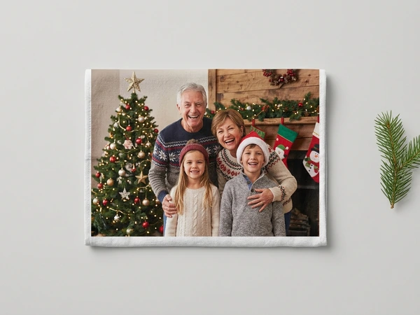 Photo towel of grandparents and two children smiling by a Christmas tree and stockings