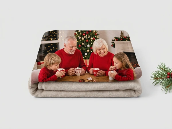 Plush blanket of grandparents sipping cocoa with a boy and a girl in red sweaters