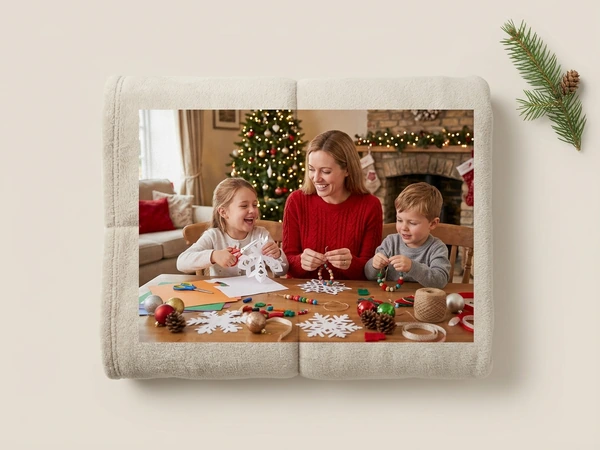 Fleece blanket of a woman and two children making paper snowflakes at a table