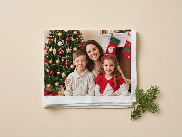 Photo towel of a woman, a boy and a girl smiling by a Christmas tree and stockings