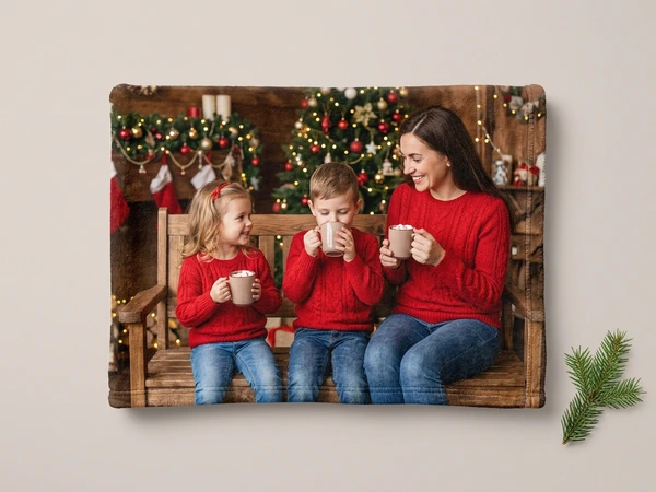 Plush blanket of a woman and two children in red sweaters sipping hot drinks on a bench
