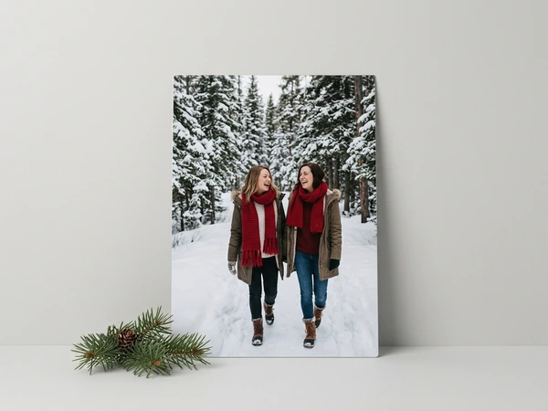 Metal print of two women in red scarves walking a snowy forest path