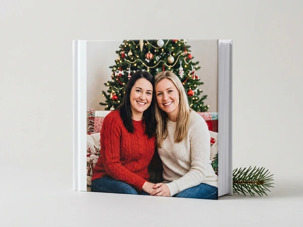 Photo book with a cover of two women on a sofa in front of a Christmas tree