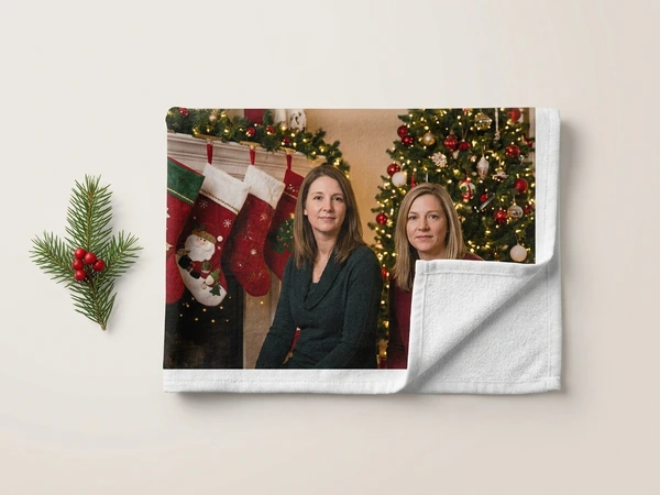 Photo towel of two women posing by stockings on a mantel and a Christmas tree