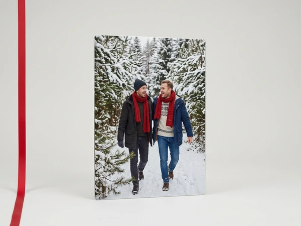 Metal print of two men in red scarves walking through a snowy pine forest