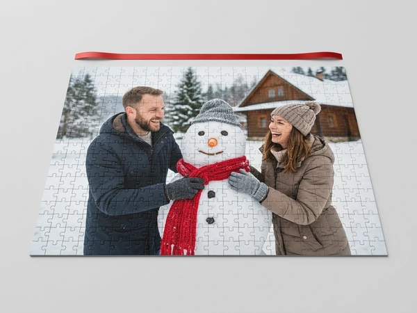 Photo puzzle of a man and a woman building a snowman in front of a snowy cabin