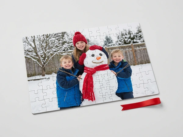 Photo puzzle of a girl and two boys in winter coats posing with a snowman in a snowy yard