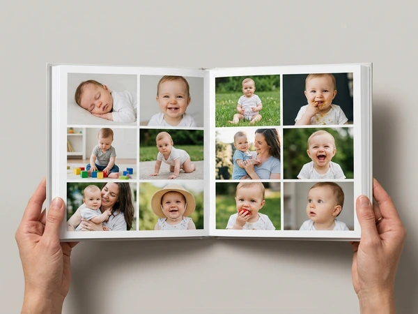 Open baby photo book with a grid of first year photos