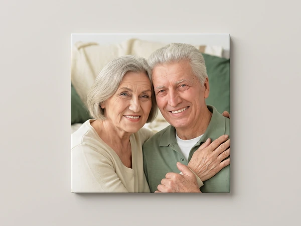 Canvas print of an elderly couple hugging on a sofa, the photo wrapping around the edges