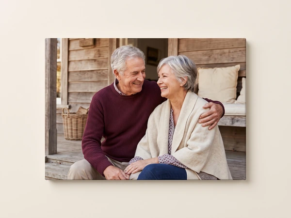 Canvas print of a gray-haired couple sitting together on a wooden porch