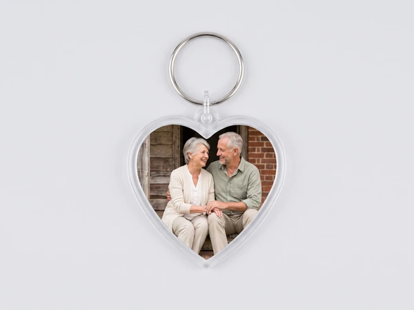 Heart keychain with a photo of an older couple sitting on a bench by a brick wall