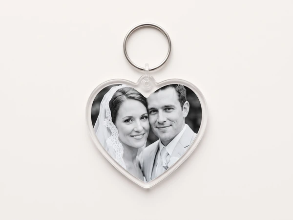 Heart keychain with a black and white photo of a bride in a veil and a groom in a light suit