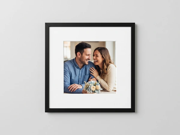 Small black framed print with a wide white mat, a couple holding pale blue flowers