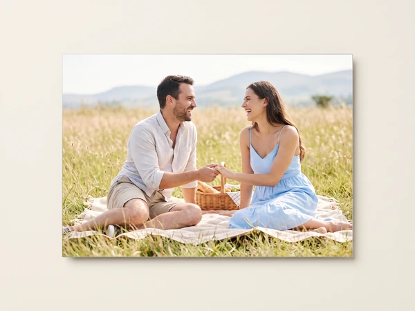 Panoramic metal print of a couple sharing a picnic in a meadow below hills