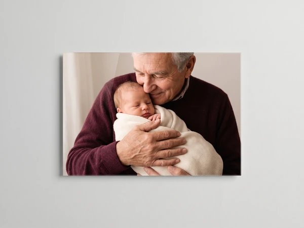 Acrylic print of a grandfather in a burgundy sweater cradling a swaddled baby