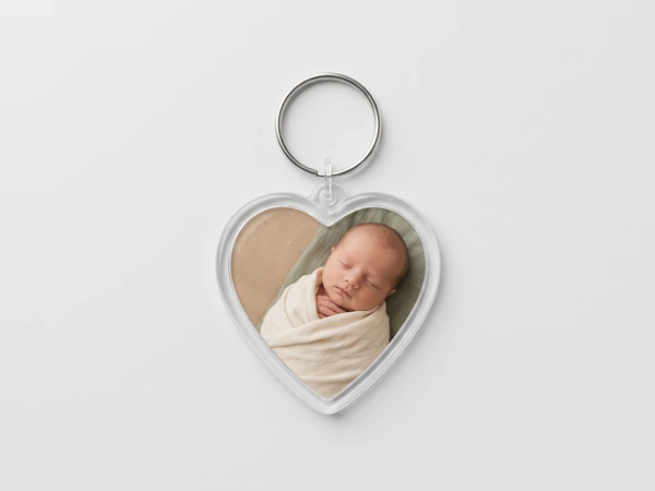 Heart keychain with a photo of a newborn swaddled in cream