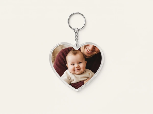 Heart keychain on a chain with a photo of a smiling baby held by a parent