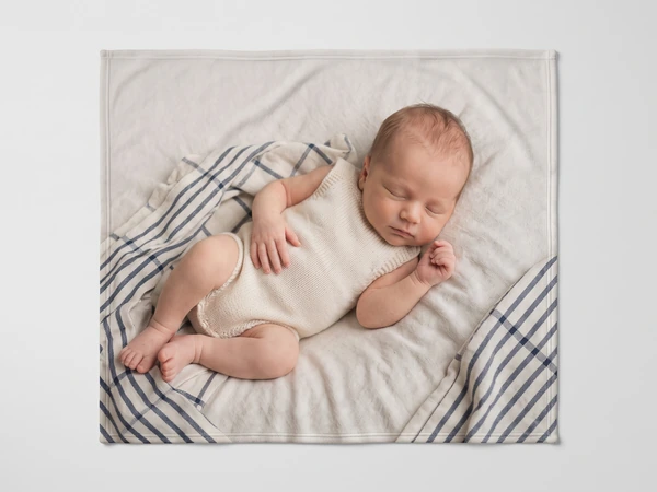 Photo blanket printed with a newborn asleep on a striped blanket