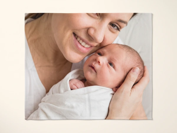 Photo blanket printed with a mother kissing a newborn in a white wrap