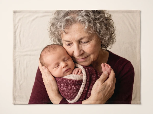 Photo blanket printed with a gray-haired grandmother cradling a newborn