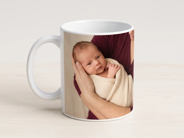 Classic photo mug printed with a parent's hands holding a swaddled newborn