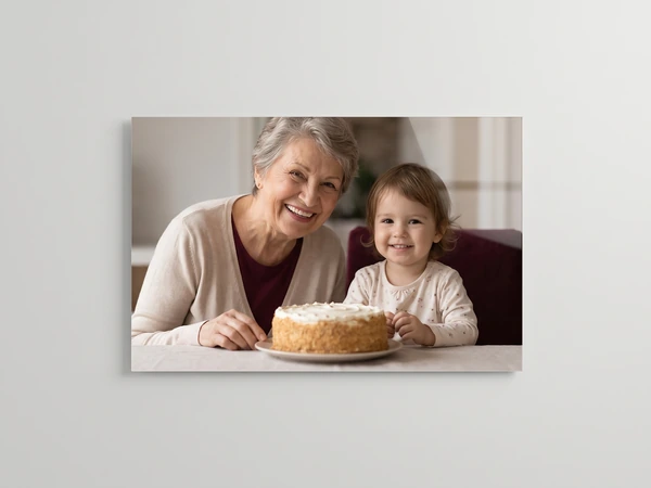 Acrylic print of a grandmother and a toddler smiling behind a birthday cake