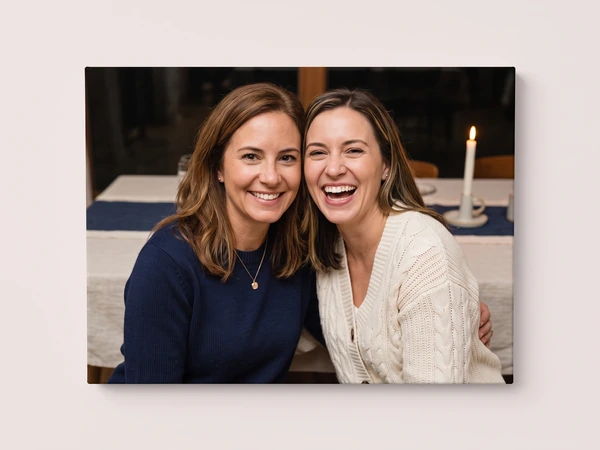 Canvas print of two women smiling at a candlelit dinner table
