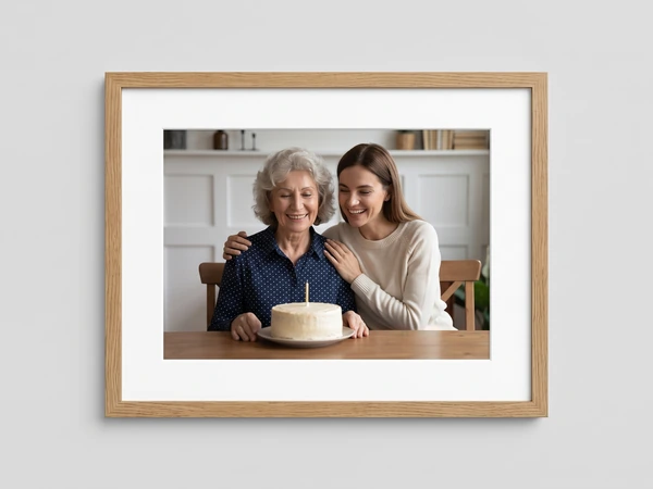 Oak framed print of a grandmother and daughter with a single-candle cake