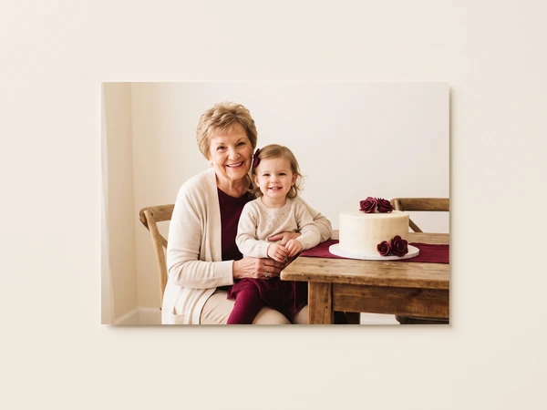 Metal print of a grandmother and toddler at a wooden table with a cake