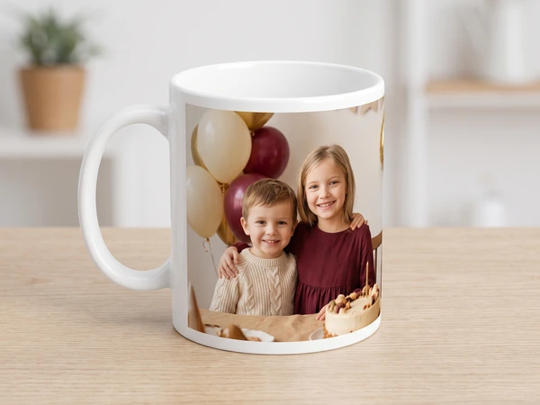 Photo mug printed with a brother and sister beside balloons and a birthday cake