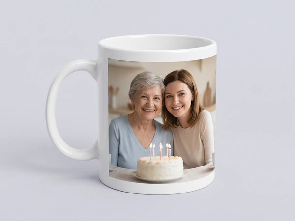 White photo mug printed with a grandmother and daughter behind a birthday cake
