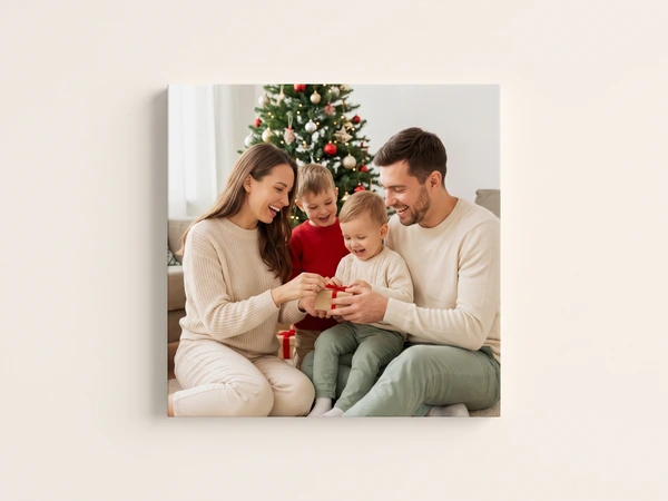 Square canvas print of a family opening a present beside a Christmas tree