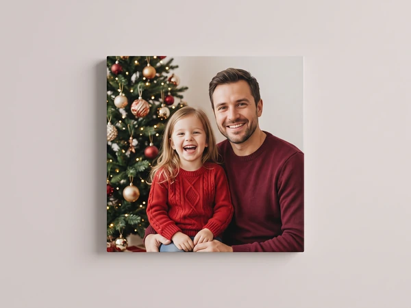Canvas print of a father and daughter in red by a decorated tree