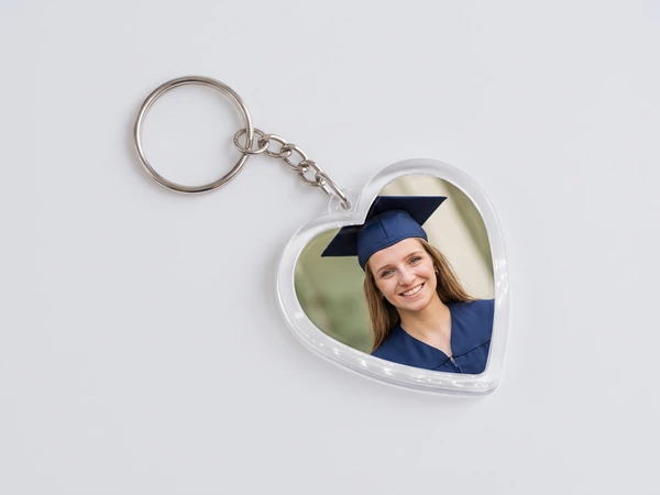 Heart keychain on a chain with a photo of a smiling graduate in a navy cap