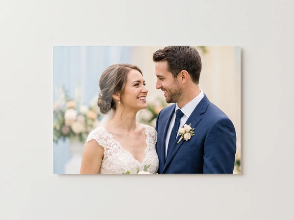 Acrylic print of a bride and groom in a navy suit smiling at each other