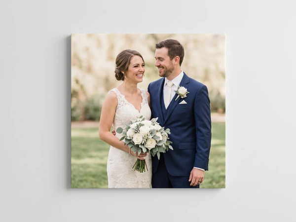 Square canvas print of a bride and groom on a lawn, the bride holding a white rose bouquet