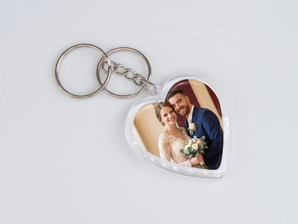 Heart keychain with two rings and a photo of a bride and groom in a navy suit