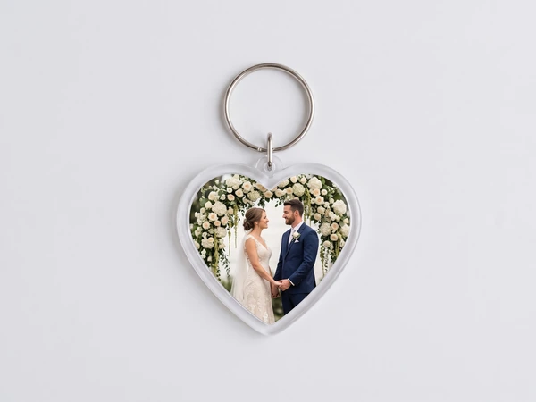 Heart keychain with a photo of a couple holding hands under a white floral arch
