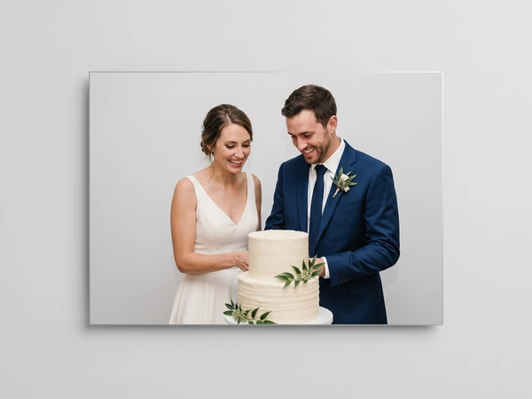 Metal print of a bride and groom cutting a white cake