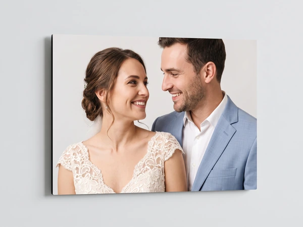 Frameless metal print of a bride and groom smiling at each other, seen at an angle