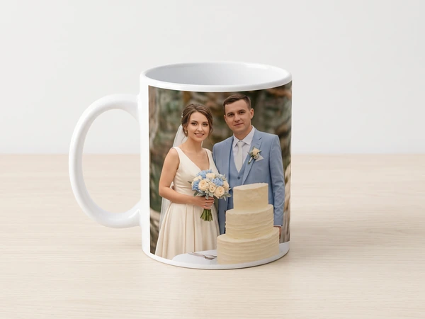 Photo mug printed with a bride and groom in a light blue suit beside a tiered cake