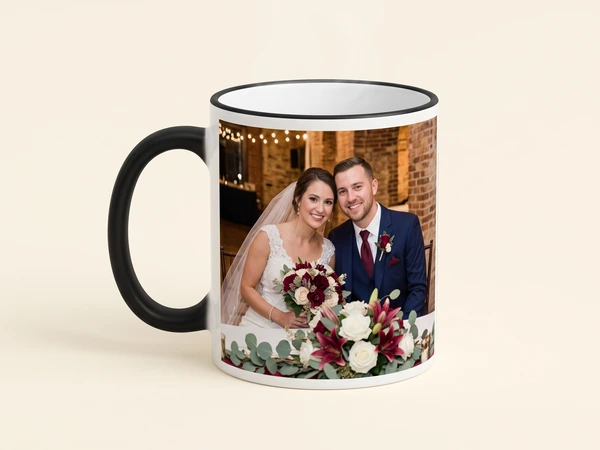 Magic mug with a black handle and rim printed with a bride and groom by a brick wall