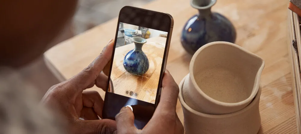 How to Resize an Image. Person taking phone photo of clay pot.