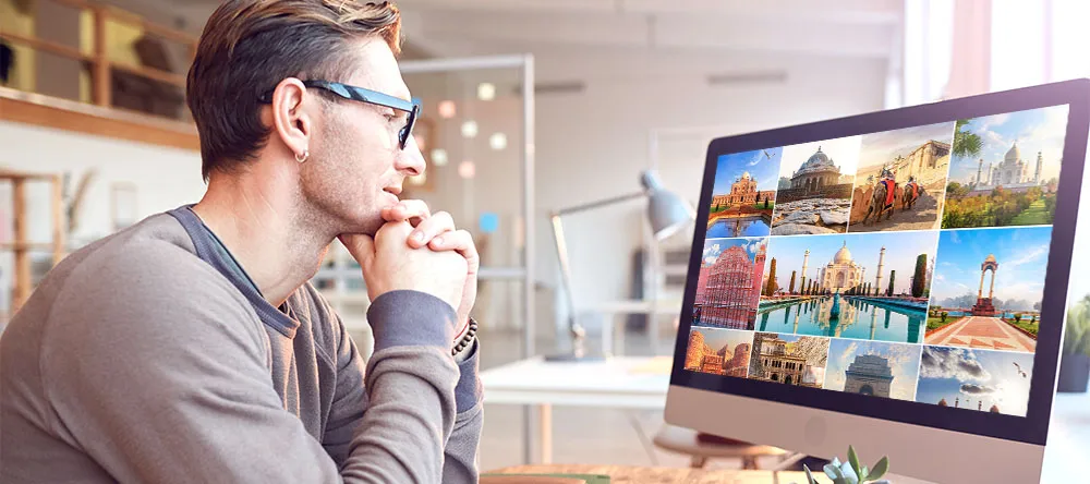 How to Make a Gallery Wall. Man looking at photos on PC.